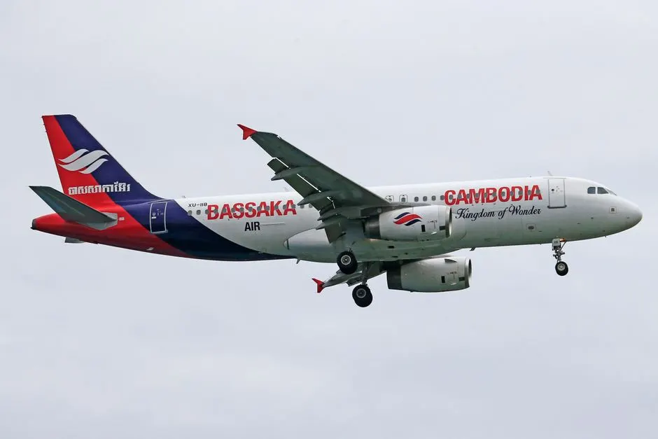 Bassaka Air Airbus A320 mid-flight under a cloudy sky.